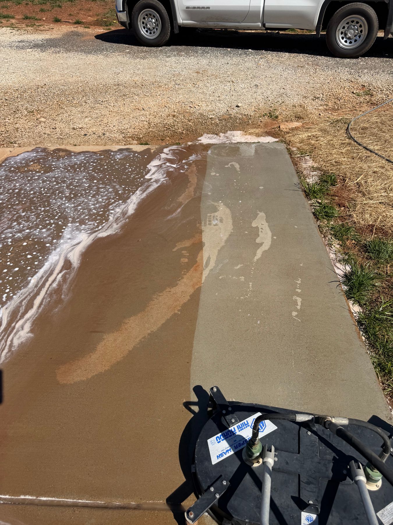 Surface cleaner revealing clean concrete